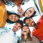 Multicultural community of young people smiling at camera outside